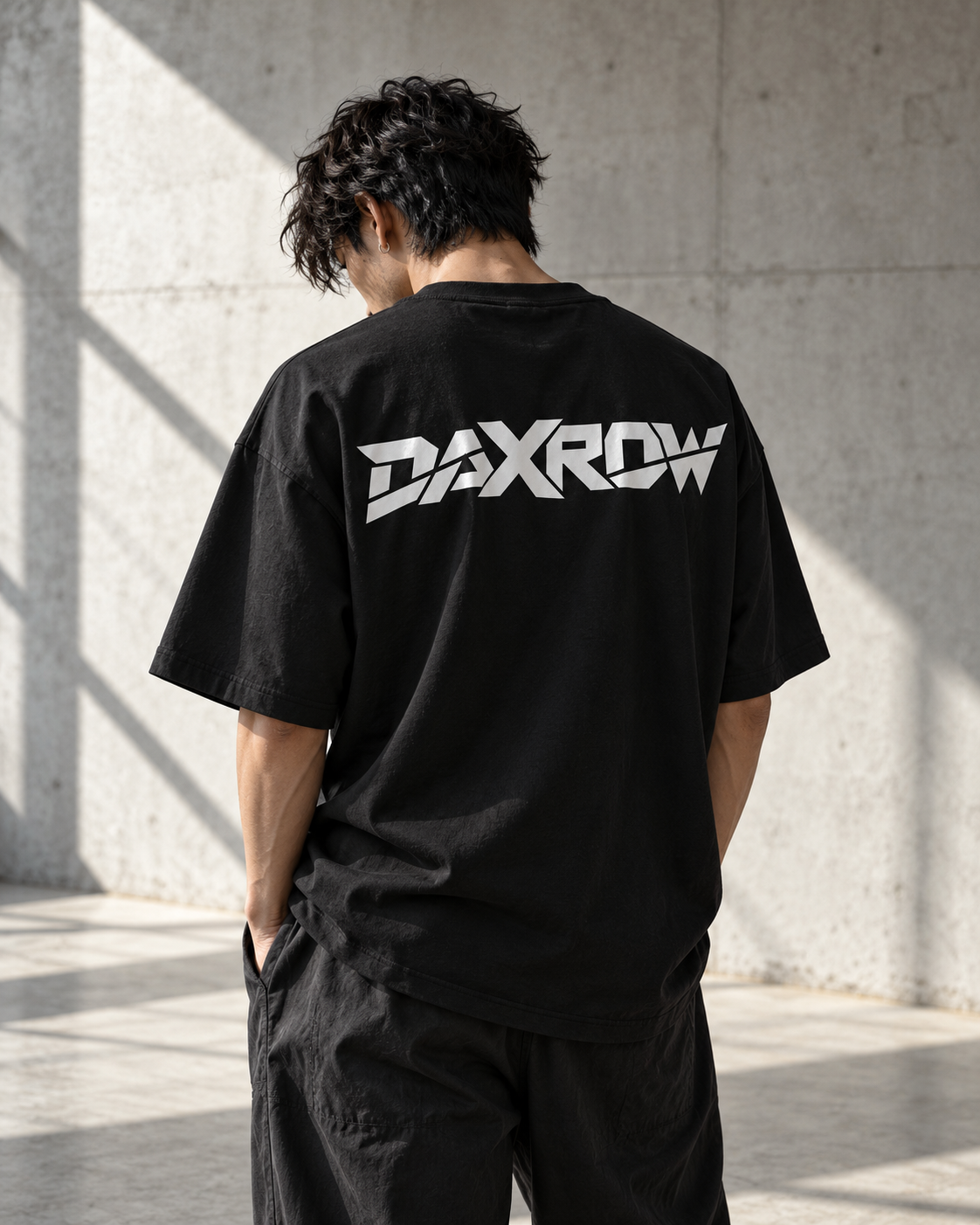 Concept de tee-shirt DAXROW noir porté de dos, dans un décor urbain